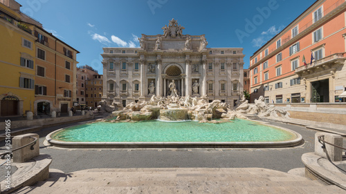 Facade and pool of the Trevi Fountain and surrounding buildings, with no visible people in the empty square of Piazza di Trevi, Rome, Italy photo