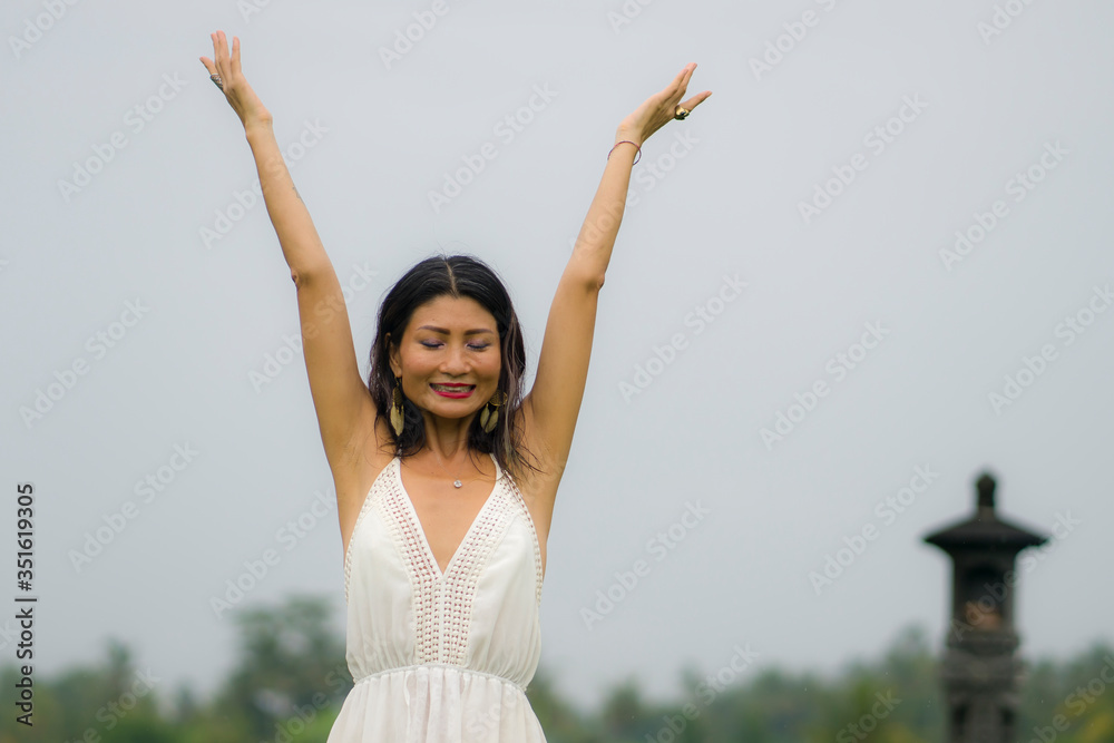 outdoors holidays portrait of attractive and happy middle aged Asian Korean woman in white dress enjoying freedom and nature at green field landscape carefree and cheerful outdoors holidays portrait of attractive and happy middle aged Asian Korean woman in white dress enjoying freedom and nature at green field landscape carefree and cheerful
