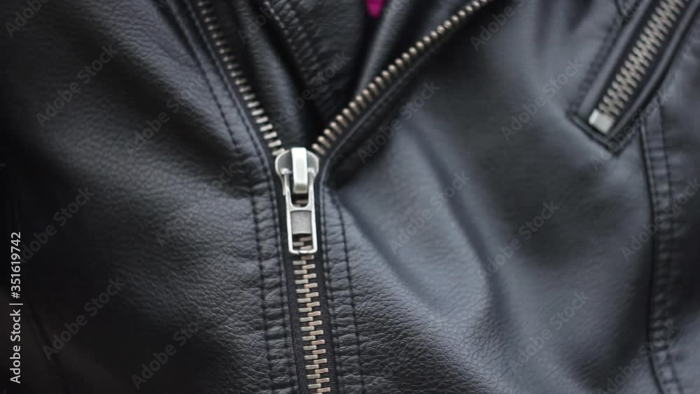 Close up woman hand zips leather jacket. Close up woman hand zips leather jacket.