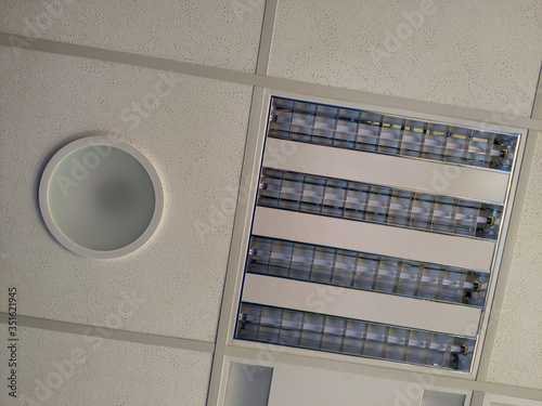 Accoustic panel and light fixtures in t-bar grid of suspended ceiling