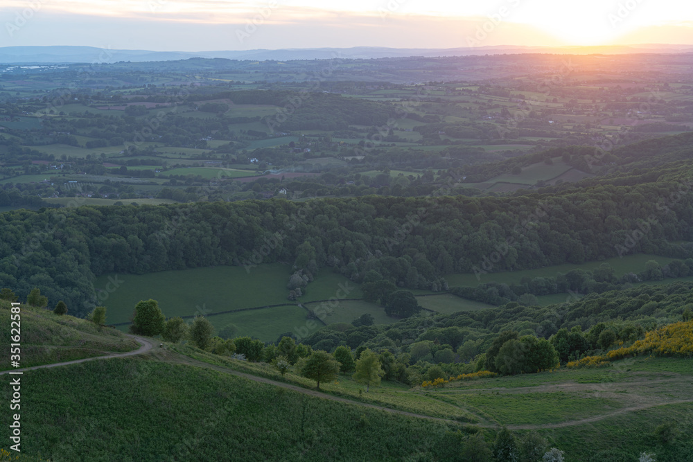 The Malvern Hills at sunset with paths and trails through the trees