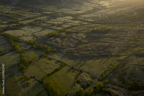 British countryside aerial view with patchwork fields at dawn