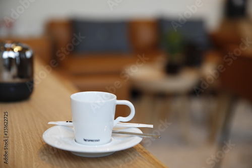 Cup of hot coffee on wooden table in a Nespresso coffee shop