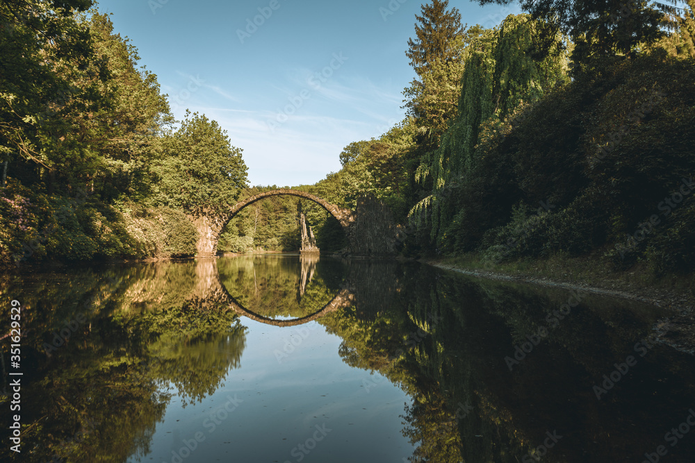 Fototapeta premium Fantastic morning scene of Azalea and Rhododendron Park Kromlau, Germany, Europe. Splendid summer view of Rakotz Bridge Rakotzbrucke, Devil's Bridge .