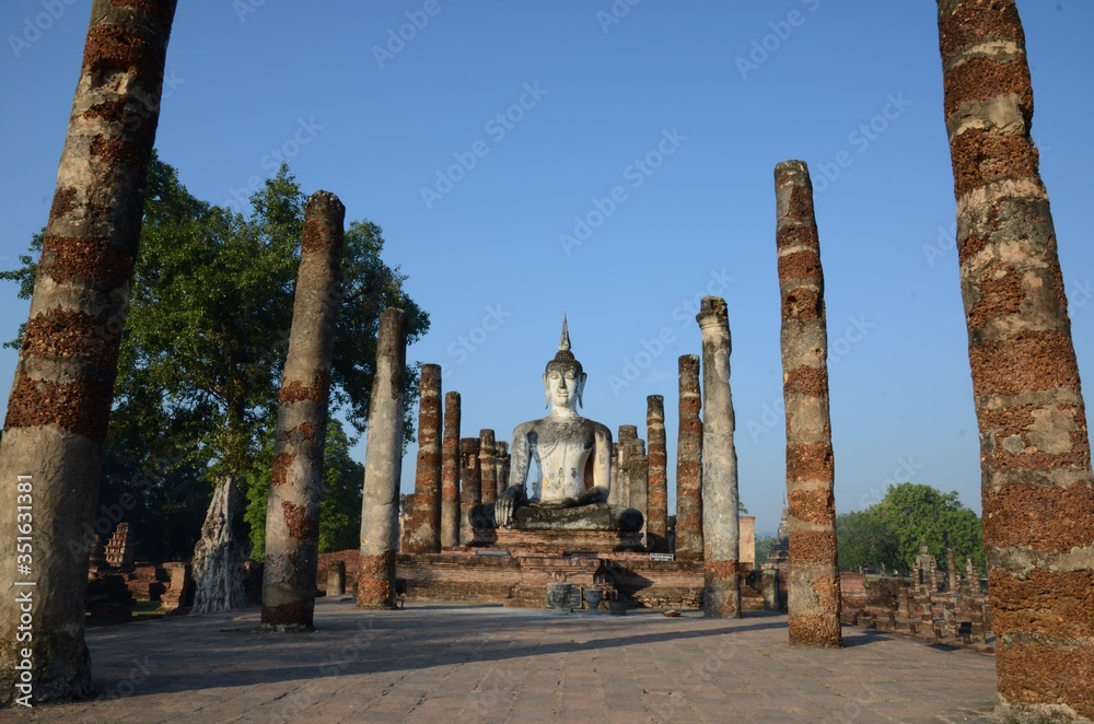 Pillars are guarding the way to a majestically sitting Buddha at Wat Mahathat in Sukhothai
