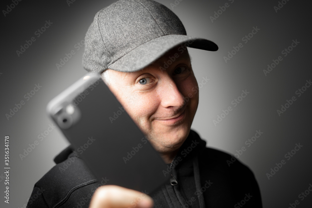 Content man in black showing smartphone to the camera Content man in black showing smartphone to the camera