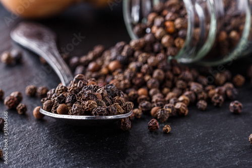 aromatic black pepper on a dark stone background