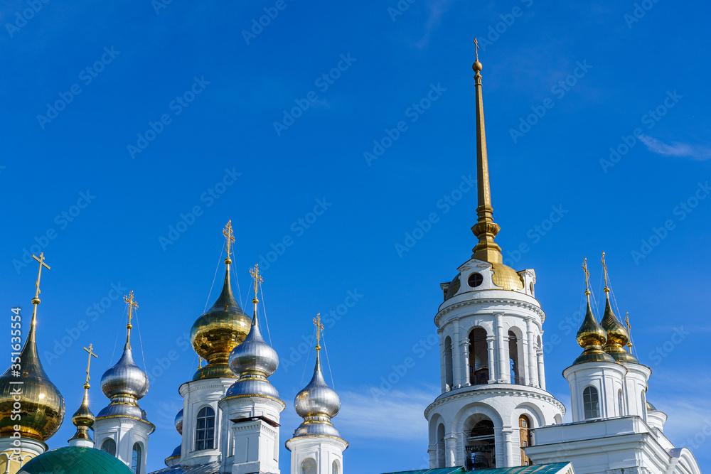 golden metal domes of an Orthodox church and the spire of a bell tower