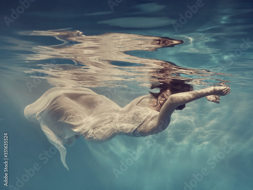 Portrait of a girl in a dress floating underwater