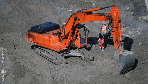 Tractors and excavators work on the construction of the foundation zero cycle