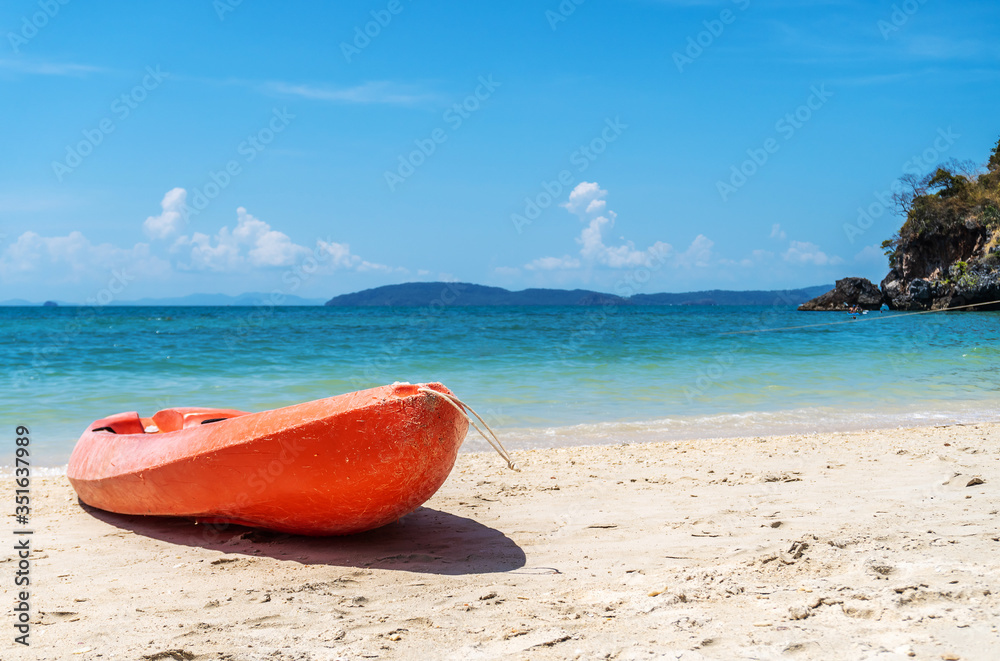 Red orange kayak on sand beach at island in tropical sea Red orange kayak on sand beach at island in tropical sea