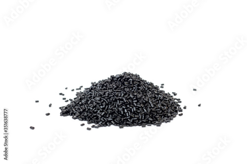 Plastic polymer granules black color on white background. Polycarbonate granules for the production of translucent structures and cellular polycarbonate