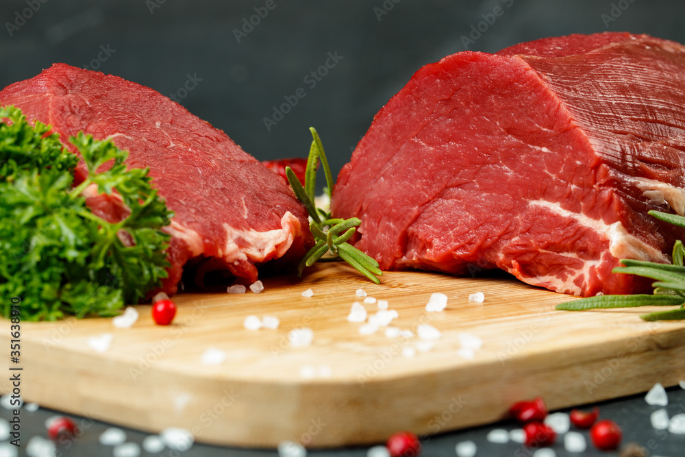 Slice of raw beef fillet on wooden board