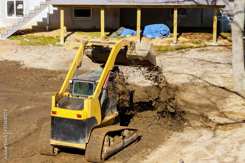Mini bulldozer landscaping works on construction working with earth while doing