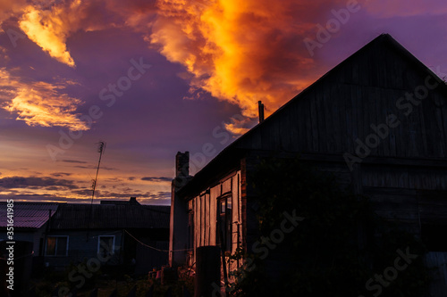 At an old wooden house in the late evening sunset before the storm