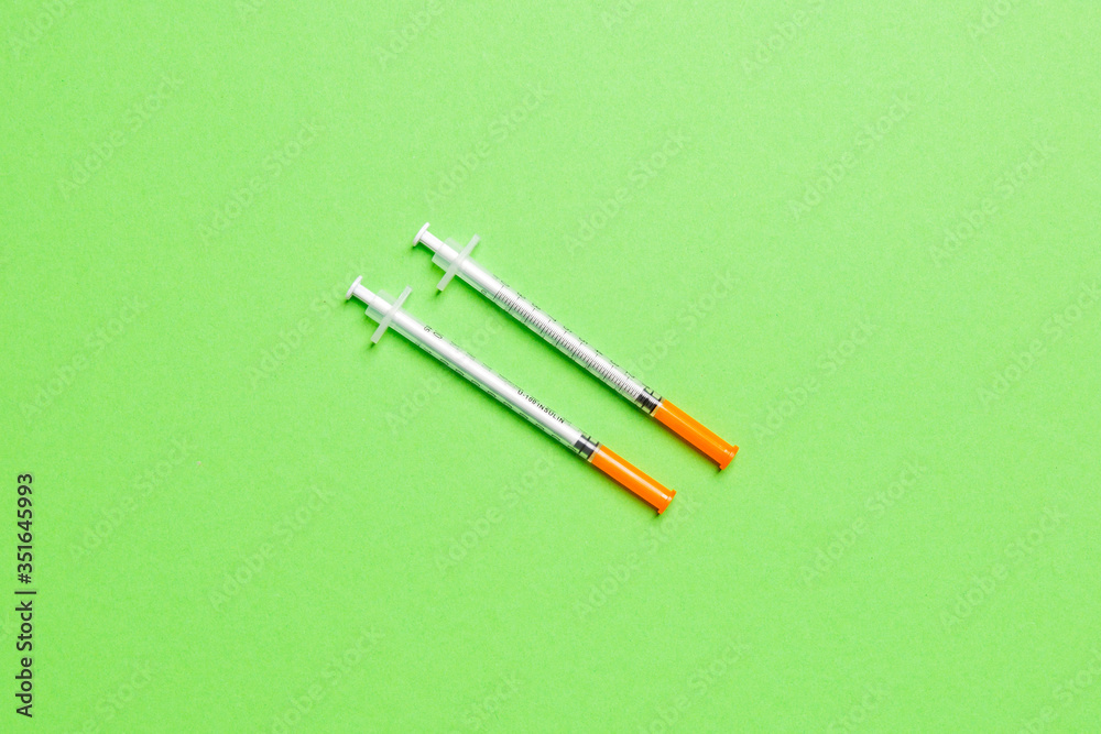 Top view of two insulin syringe at colorful background with copy space. High level of glucose concept Top view of two insulin syringe at colorful background with copy space. High level of glucose concept