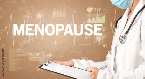 young doctor writing down notes with MENOPAUSE inscription, healthcare concept