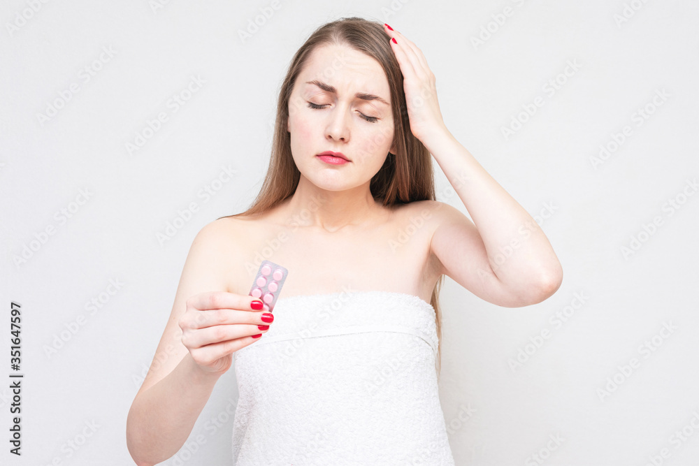 Girl has a headache, woman got sick, holding the medicine in his hand, close up Girl has a headache, woman got sick, holding the medicine in his hand, close up