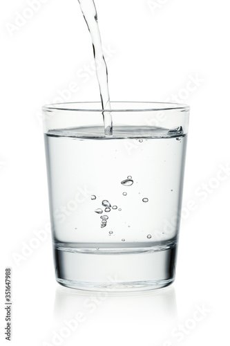 Pouring water on a glass isolated on a white background.