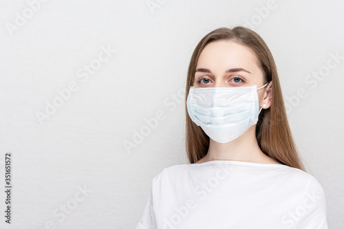 Beautiful woman wearing medical face mask because of air, white background, copy space