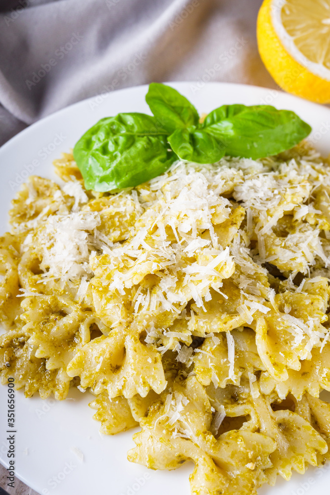 Delicious farfalle pasta with pesto sauce on wooden rustic background Delicious farfalle pasta with pesto sauce on wooden rustic background