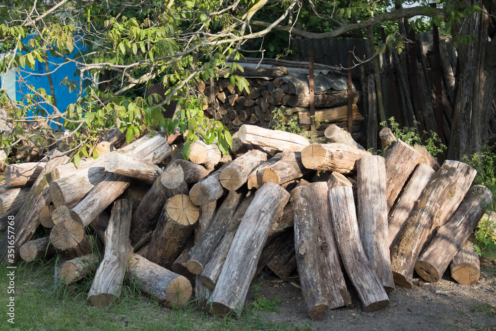 Pile of logs close-up in the countryside. Harvesting firewood for the winter for the bath. Dry round logs with cracks Pile of logs close-up in the countryside. Harvesting firewood for the winter for the bath. Dry round logs with cracks