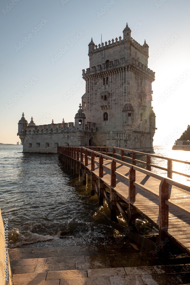 Silhouette of the Belem Tower in Lisbon illuminated by the setting sun.