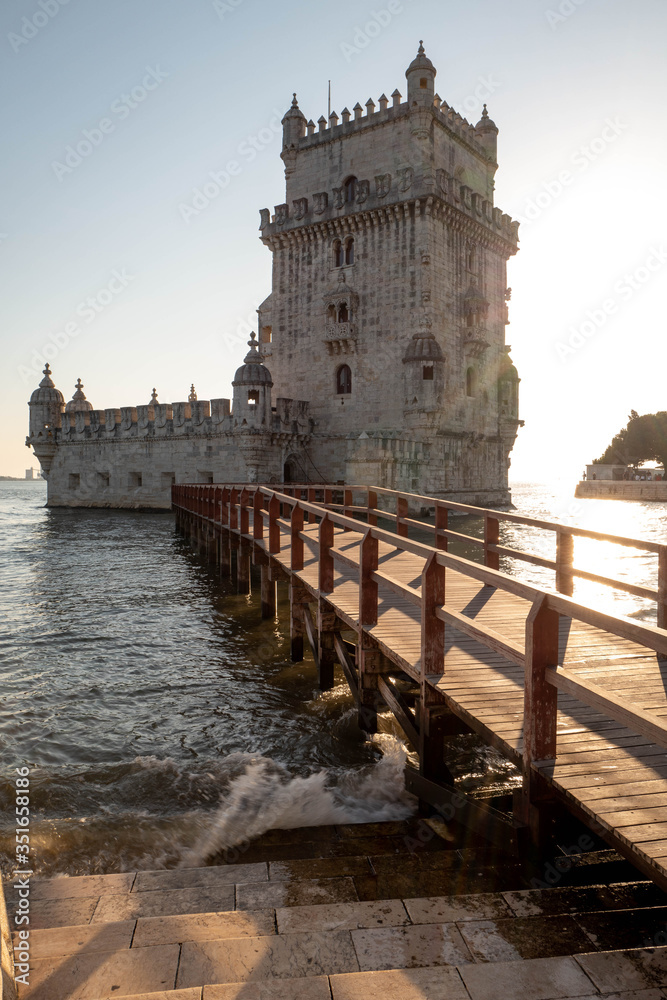 Silhouette of the Belem Tower in Lisbon illuminated by the setting sun.