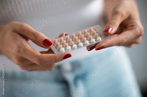 Woman holding a contraceptive pills. Concept of contraception methods. photo