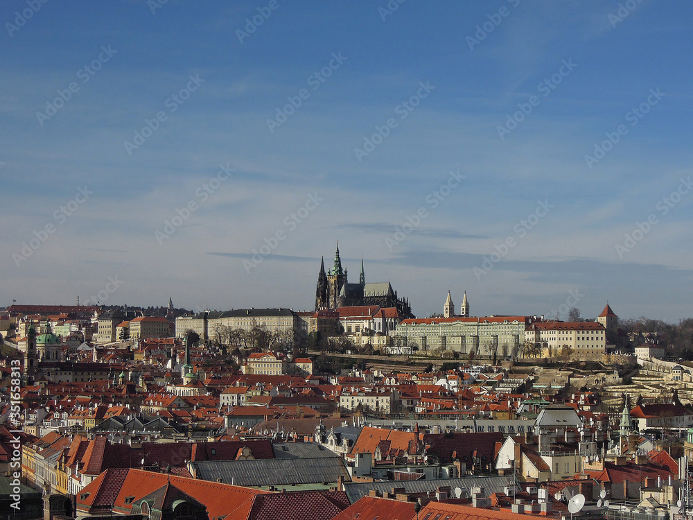 Fototapeta premium Panoramic view on Prague buildings surrounding Old Town Square and on St Vitus Cathedral from Old City Hall tower. These are ones of most popular tourist routes in capital of Czech Republic