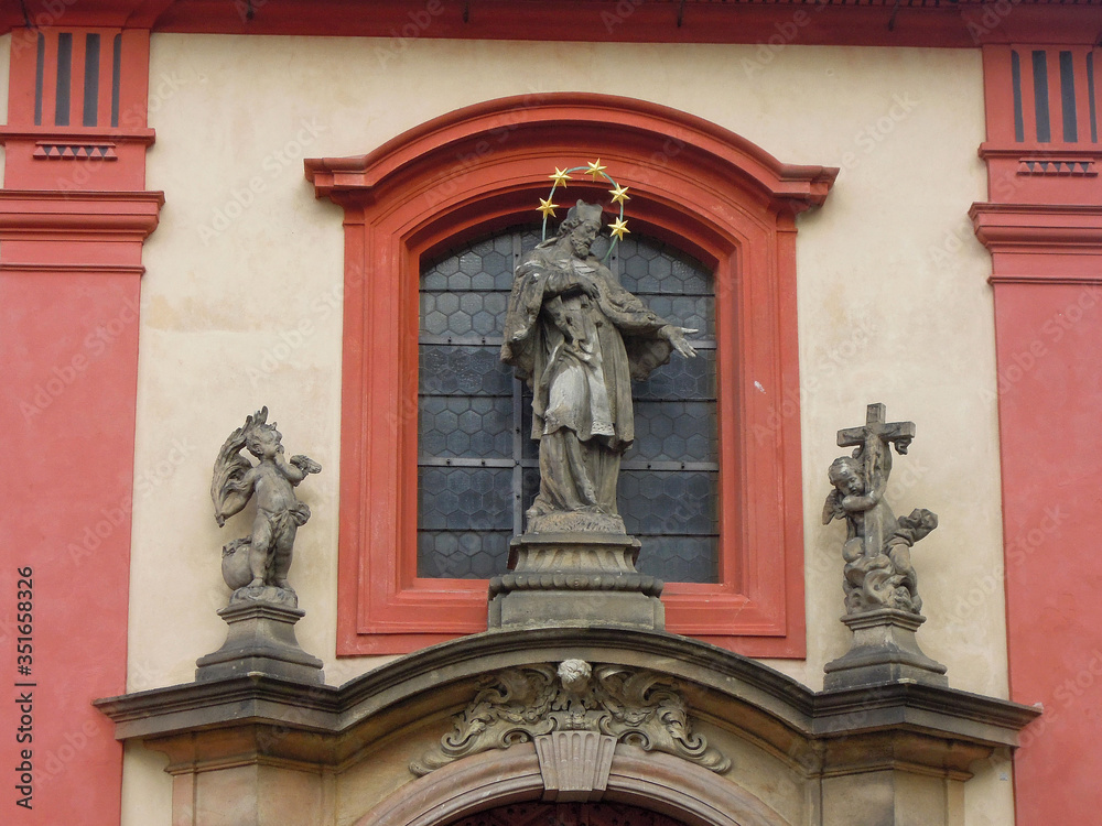 Statue of Czech saint John of Nepomuk, decorating St. George's Basilica, Prague, Czech Republic. Building is most oldest surviving church withing Prague Castle. Church is also serves as concert hall