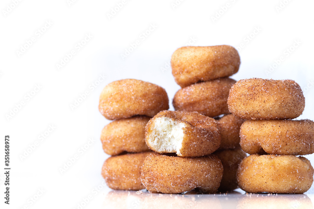 Cinnamon Sugar Mini Donuts in a stack on white background with copy space