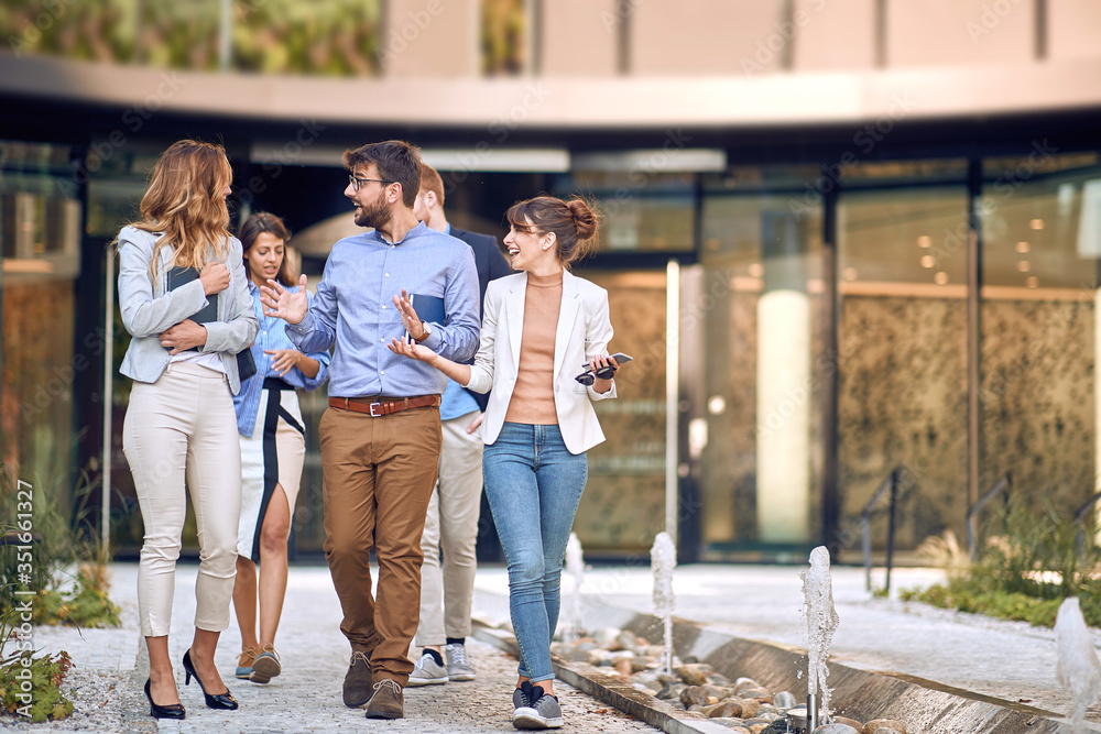 group of young businesspeople walking in front of the building. group of young businesspeople walking in front of the building.