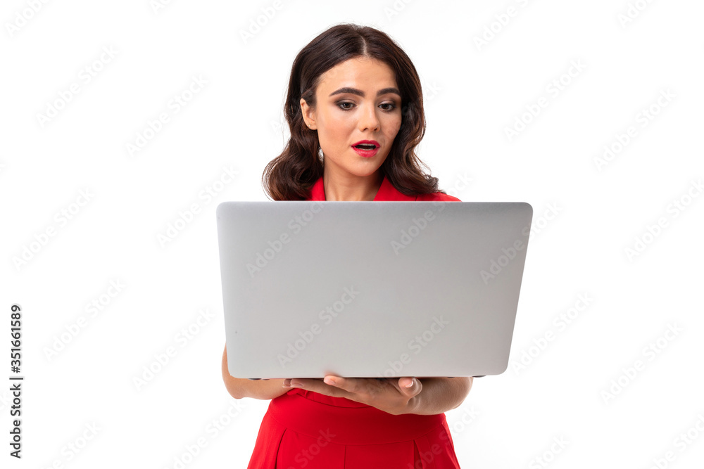 cute young woman in red dress holds laptop with screen forward on a white background cute young woman in red dress holds laptop with screen forward on a white background