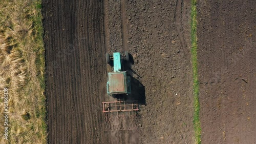 top view, aerial view. the tractor cultivates the land. preparation for growing crops. agriculture in the village and in the countryside.