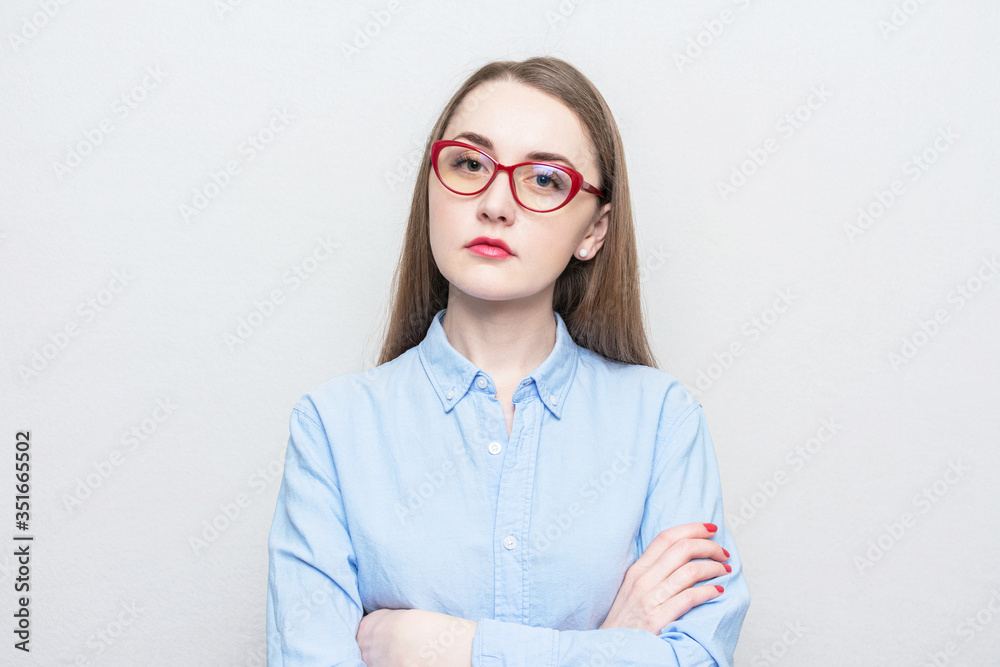 Nerd girl in red glasses looks thoughtfully at the camera, portrait, white background Nerd girl in red glasses looks thoughtfully at the camera, portrait, white background