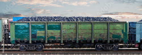 Railway wagon loaded with coal. Coal freight train at the railway station. Coal wagon, mining and transportation of minerals by rail photo