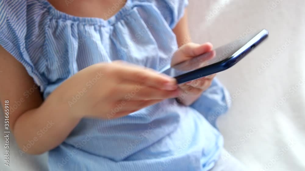 Close-up of hand girl using smartphone while sitting on the sofa in the living room at home