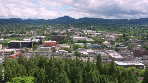 Aerial view looking towards Eugene Oregon above trees viewing mountains on cloudy day.