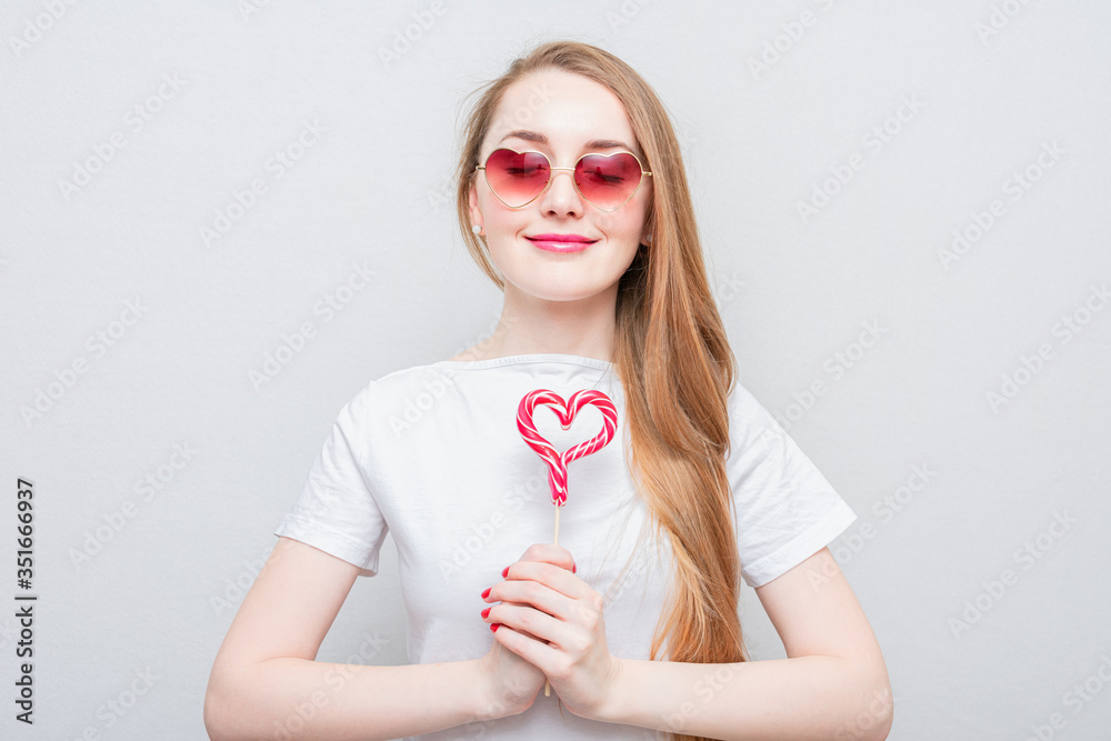 Girl was given a candy in the shape of a heart, a woman heart-shaped glasses, white background Girl was given a candy in the shape of a heart, a woman heart-shaped glasses, white background