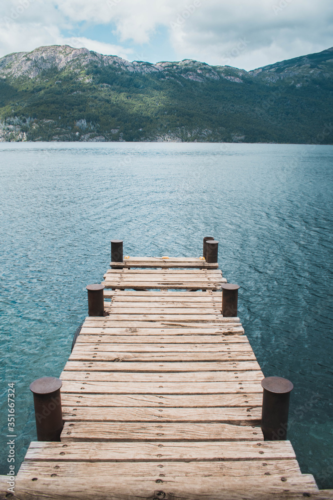 Mulle de madera en lago azul frente a cerro verde