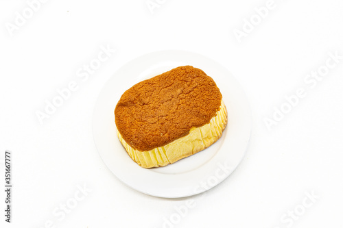 Sponge cake is on white plate and white background .Sponge cake is a light cake made with eggs, flour and sugar, sometimes leavened with baking powder.