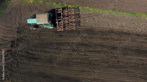 top view, aerial view. the tractor cultivates the land. preparation for growing crops. agriculture in the village and in the countryside.