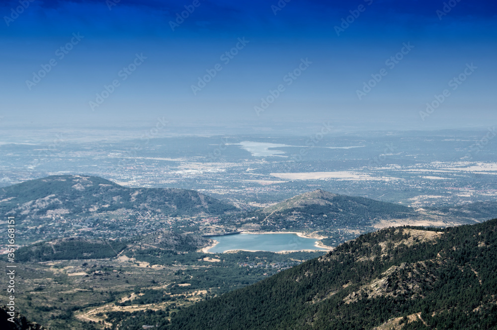 plain with reservoir seen from a mountain in national guadarrama park in Madrid. Spain