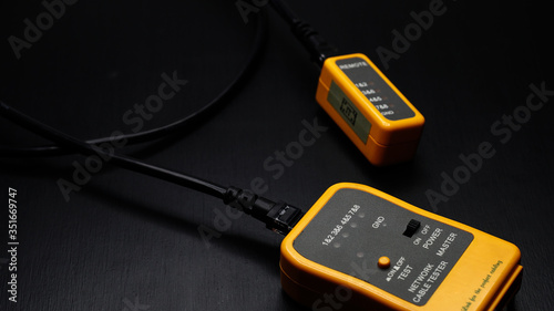  qualified cable performance tester. Technician measure a cables connected a black background.