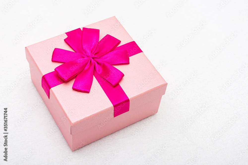 Beautiful gift with pink ribbon for Birthday, white background, close-up, top view Beautiful gift with pink ribbon for Birthday, white background, close-up, top view