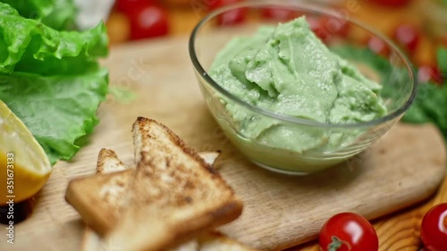 Toasts and guacamole with A variety of fresh summer products on the table in slow motion. Cooking a delicious healthy vegetarian breakfast. Healthy eating and healthy lifestyle.