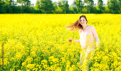 Girl in a blooming rapeseed field, cheerful happiness © miroslavmisiura