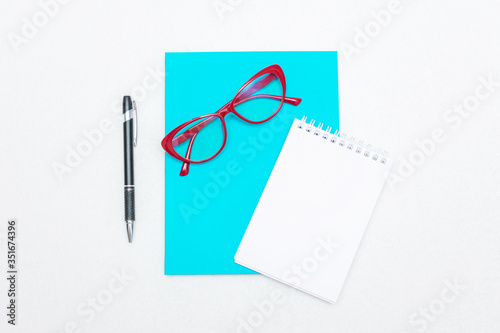 Two notebooks, pen and red women's glasses, white background, top view, copy space