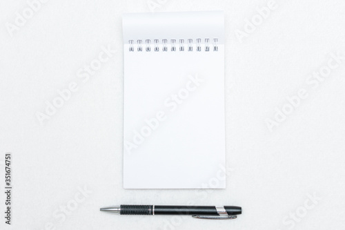 Notepad and pen on white background, copy space